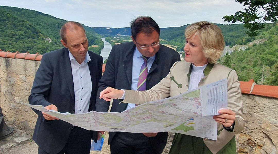 Kartenvorstellung auf Burg Prunn im Altmühltal Drei Personen schauen auf eine Karte